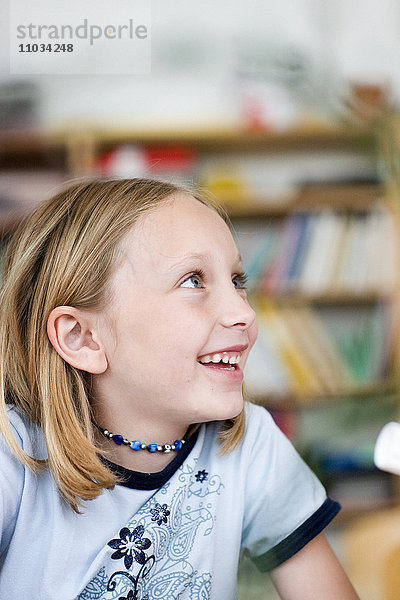 Ein lächelndes Mädchen in einem Klassenzimmer  Schweden.