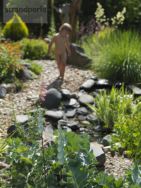 Junge spielt im Garten  Dekoration im Vordergrund