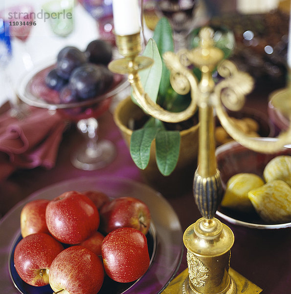 Früchte und ein Kerzenständer auf einem Tisch.