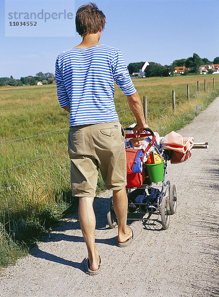 Vater mit Kinderwagen.