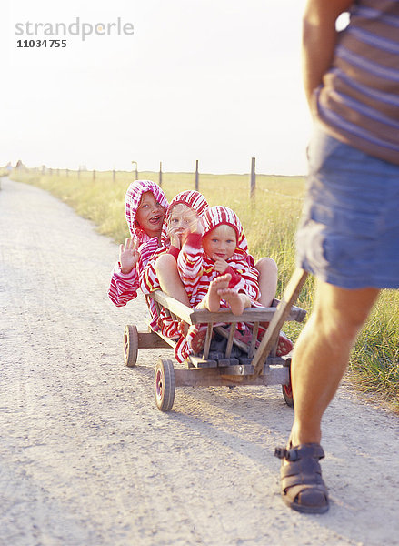 Mutter mit Kindern in einem Planwagen.