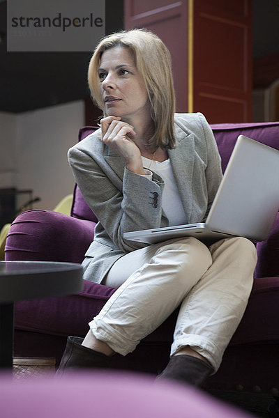 Geschäftsfrau sitzt in einem Café und benutzt einen Laptop