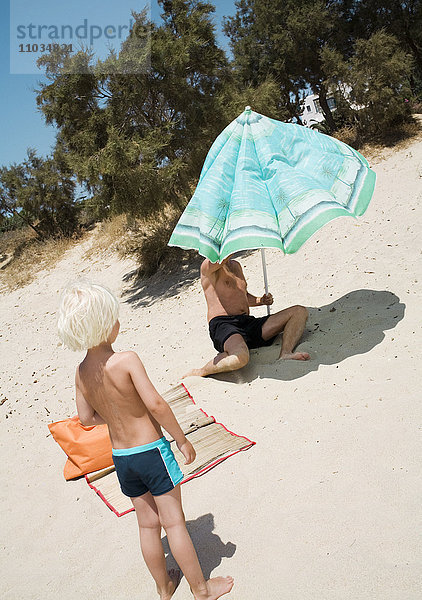 Ein Mann und ein Junge am Strand.