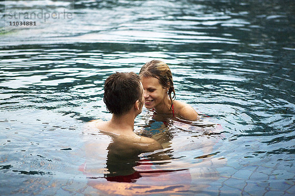 Ein junges skandinavisches Paar beim Baden in einem Swimmingpool  Thailand.