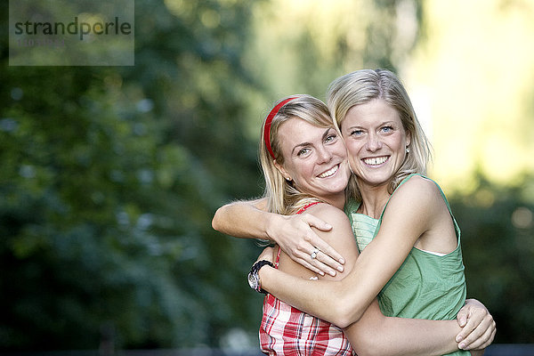 Zwei lächelnde Frauen  die sich umarmen  Schweden.