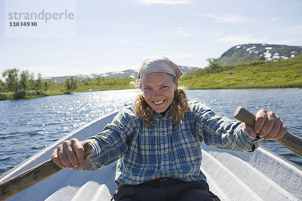 Eine Frau rudert ein Boot  Hemavan  Schweden.