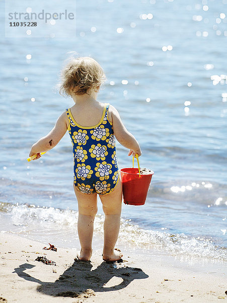 Ein Mädchen spielt am Strand  Schweden.