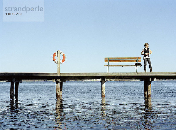 Eine junge Frau auf einem Bootssteg  Schweden.