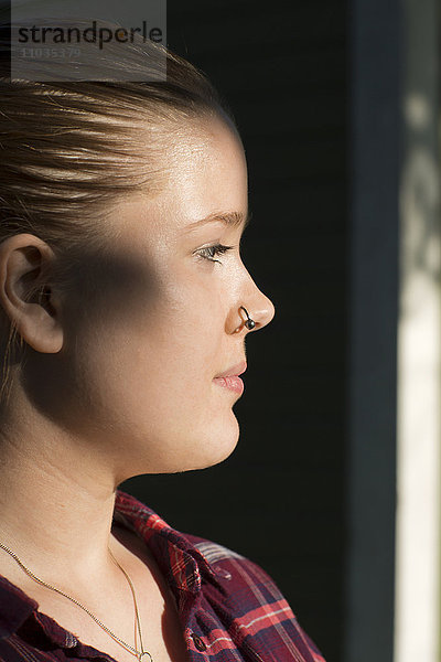 Profil einer jungen Frau mit Nasenring