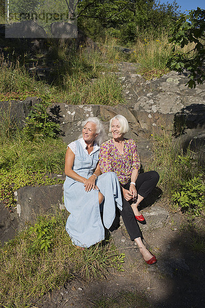 Zwei reife Freunde sitzen auf einem Stein
