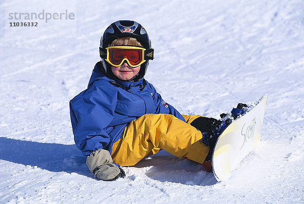 Ein kleiner Junge auf einem Snowboard  Schweden.