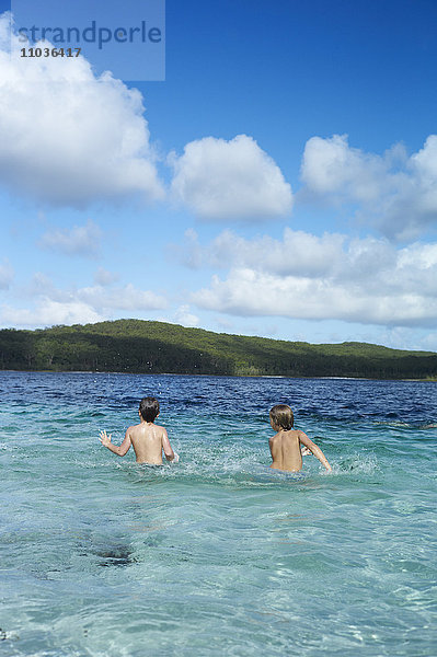 Jungen spielen im Meer  Australien