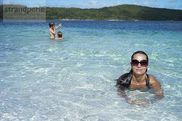 Frau schwimmt im Meer  zwei Jungen im Hintergrund  Fraser Island  Australien