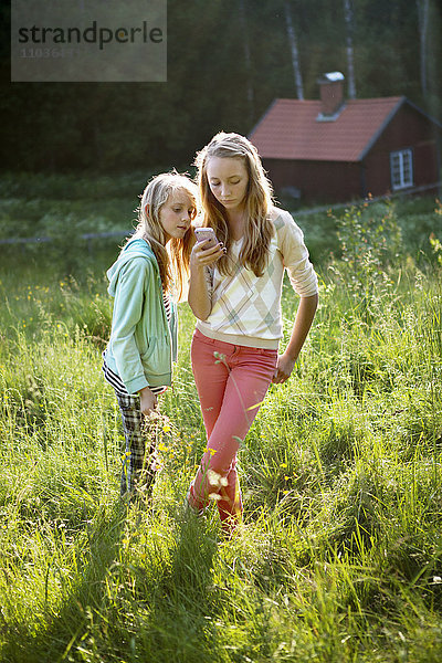 Mädchen mit Handy auf Wiese