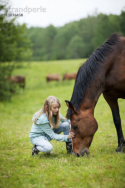 Mädchen mit Pferd auf Wiese