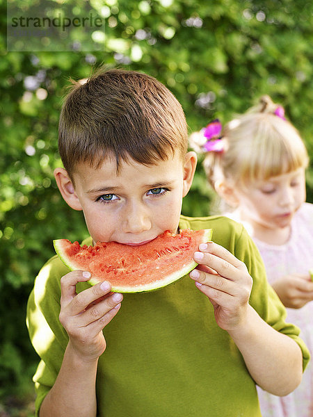 Junge und Mädchen essen Wassermelone  Schweden.