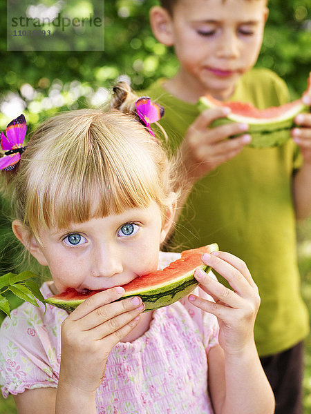 Junge und Mädchen essen Wassermelone  Schweden.