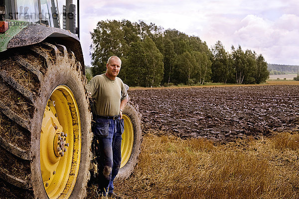 Ein Landwirt und ein Traktor auf einem Feld  Schweden.