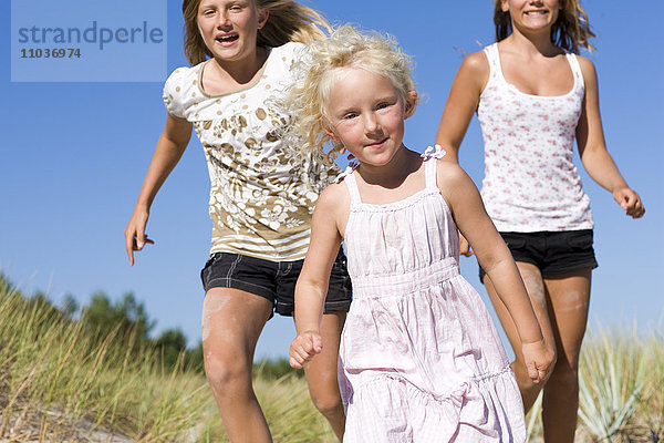 Drei Mädchen laufen am Strand  Schweden.