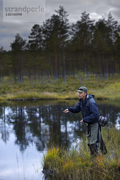 Ein Mann beim Fliegenfischen  Schweden.