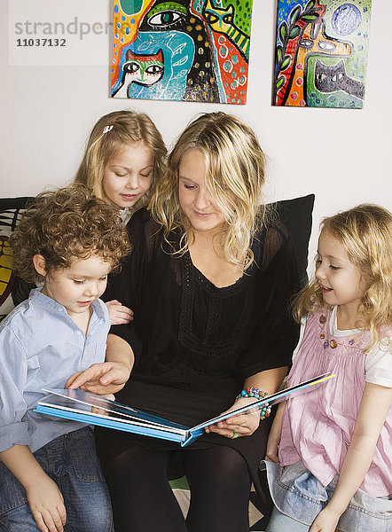 Eine Mutter liest ihren Kindern vor  Schweden.