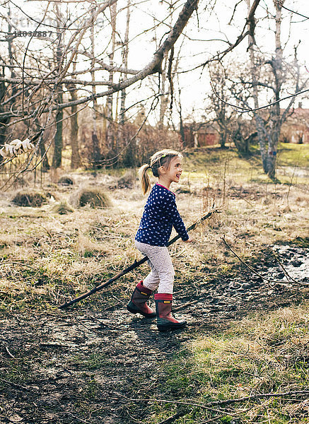 Mädchen  das im Vorfrühling in einem Garten spielt  Schweden.