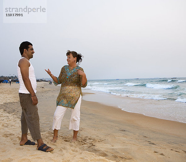 Mann und Frau unterhalten sich am Strand  Indien.
