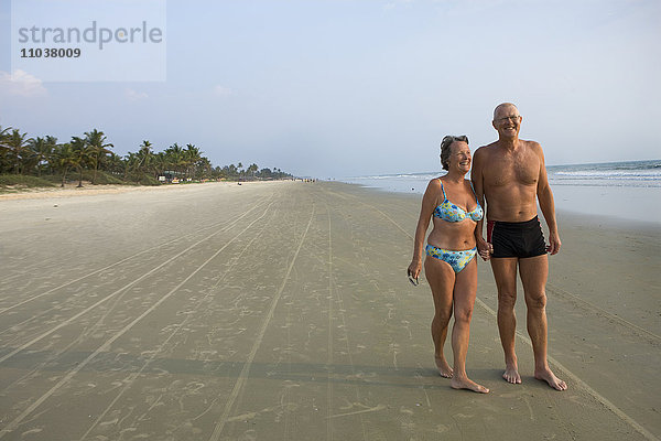 Ein älteres Ehepaar  das am Strand spazieren geht  Thailand.