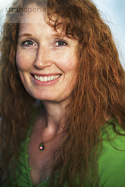 Porträt einer rothaarigen lächelnden Frau.