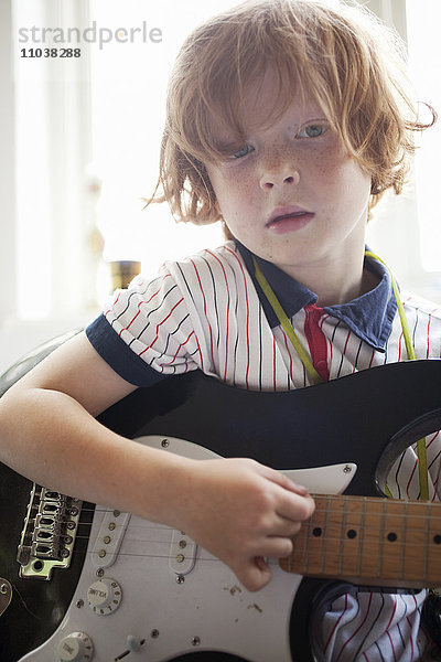 Rothaariger Junge spielt E-Gitarre  Schweden.