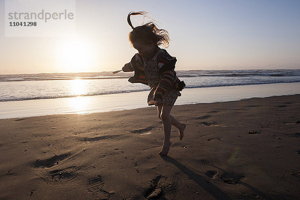 Kleines Mädchen  das am Strand rennt