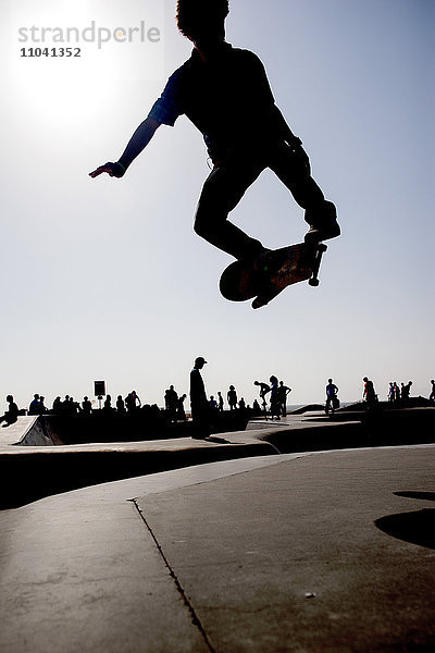 Skateboarder in der Luft im Skatepark
