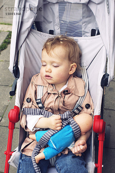 Kleinkind schläft im Kinderwagen