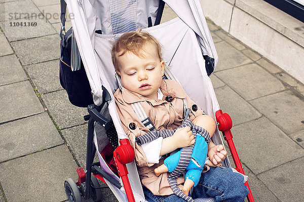 Kleinkind schläft im Kinderwagen