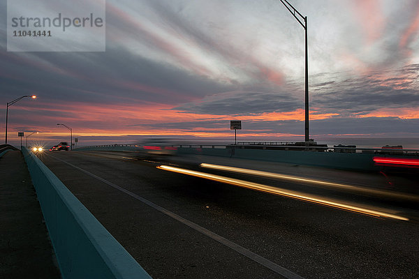 Lichtspuren vom Verkehr auf der Autobahn bei Sonnenuntergang