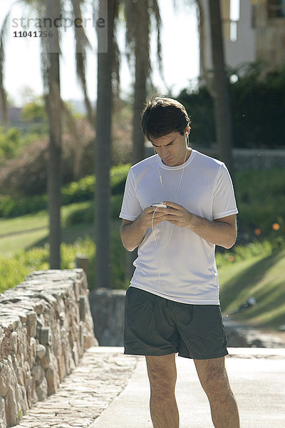 Jogger überprüft Smartphone im Park