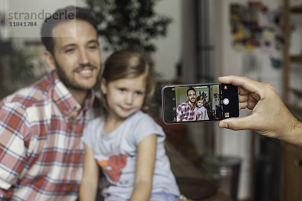 Fotografieren von Vater und Tochter mit dem Smartphone