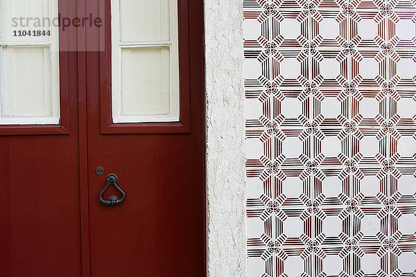 Rote Tür und verzierte Fliesenwand