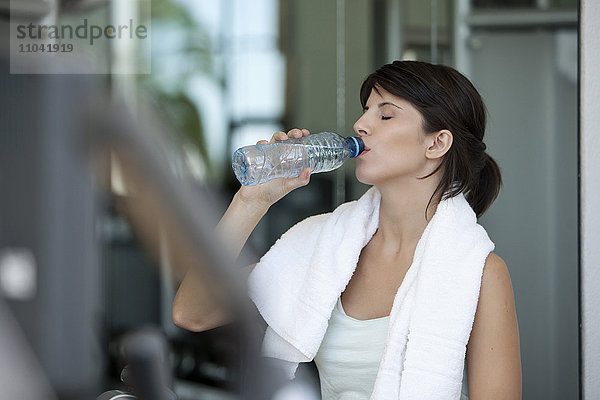 Frau trinkt Wasser in Flaschen nach dem Training