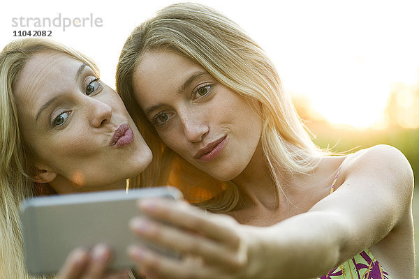 Paar posieren Wange an Wange für Smartphone Selfie
