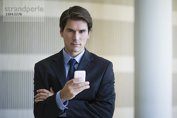 Geschäftsmann SMS mit Handy  Portrait