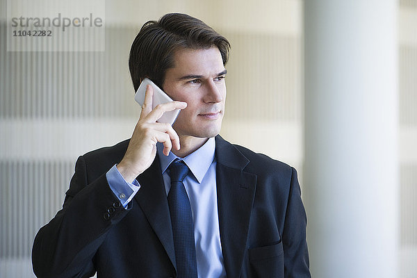 Geschäftsmann hört Voicemail auf dem Handy ab
