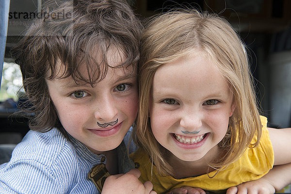 Junge Geschwister mit gefälschtem Schnurrbart  Portrait
