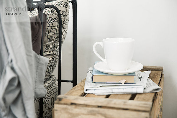 Kaffeetasse und Buch auf Nachttisch