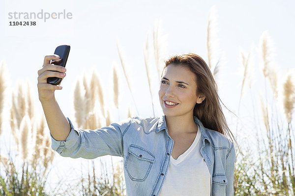 Frau posiert für einen Selfie im Freien