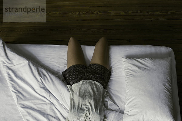 Frau im Bett liegend  zögernd aufzustehen und den Tag zu beginnen.