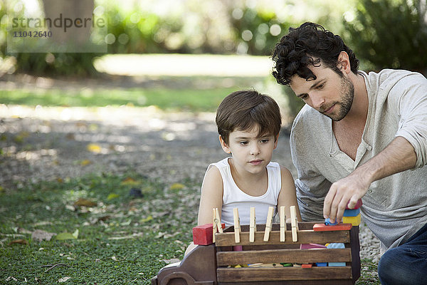 Vater und Sohn spielen mit Spielzeug im Hinterhof