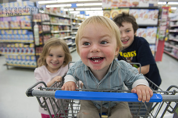 Kinder haben Spaß im Warenkorb