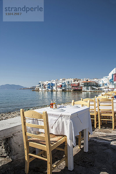 Tische im Hafencafé unter blauem Himmel
