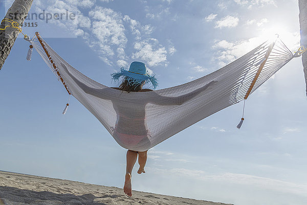 Kaukasische Frau in Hängematte am Strand